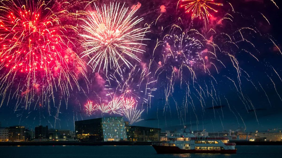 Red and pink New Year's Eve fireworks over the Reykjavík skyline
